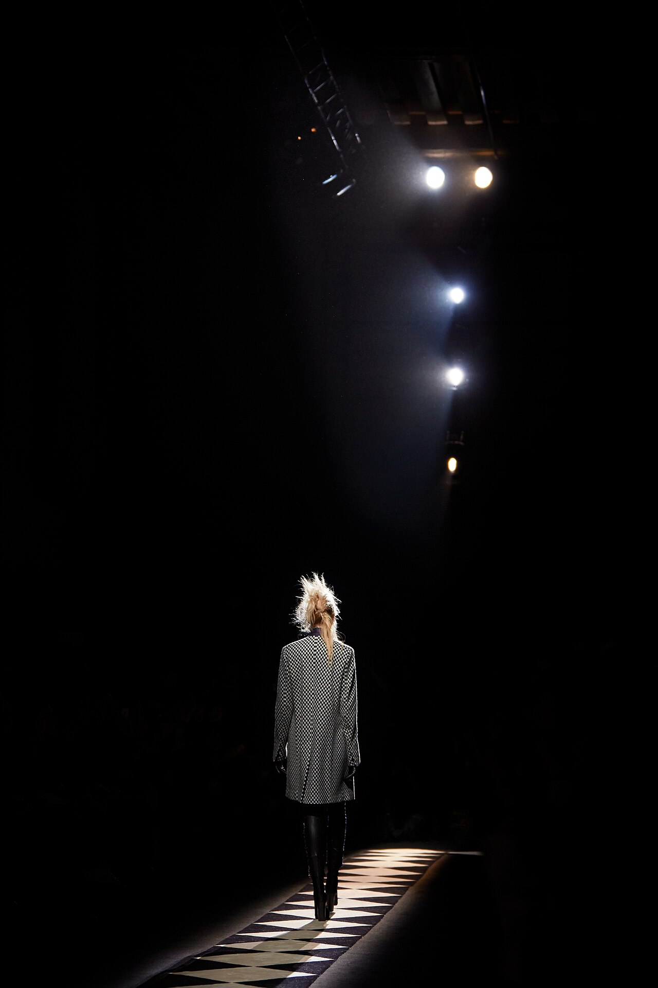 Model on the runway under a spotlight, Paris Fashion Week